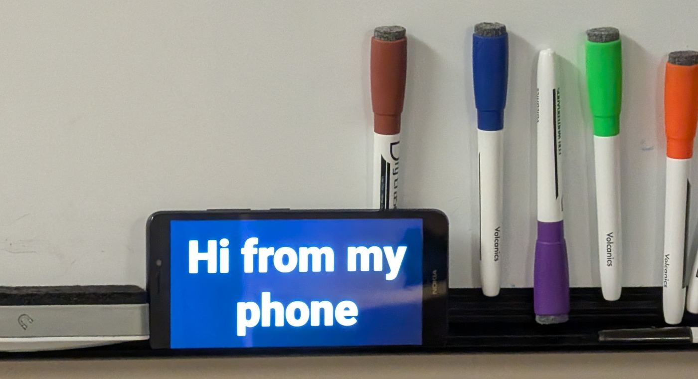 The Nokia on the whiteboard showing "Hi from my phone"